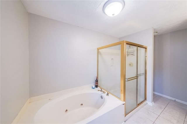 bathroom featuring tile patterned flooring, a stall shower, a jetted tub, and a textured ceiling