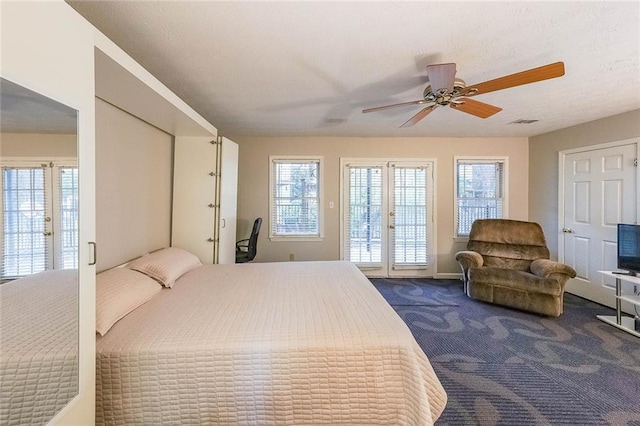 bedroom with access to outside, visible vents, dark colored carpet, and ceiling fan