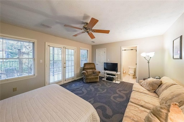 bedroom with access to exterior, a ceiling fan, ensuite bathroom, and a textured ceiling