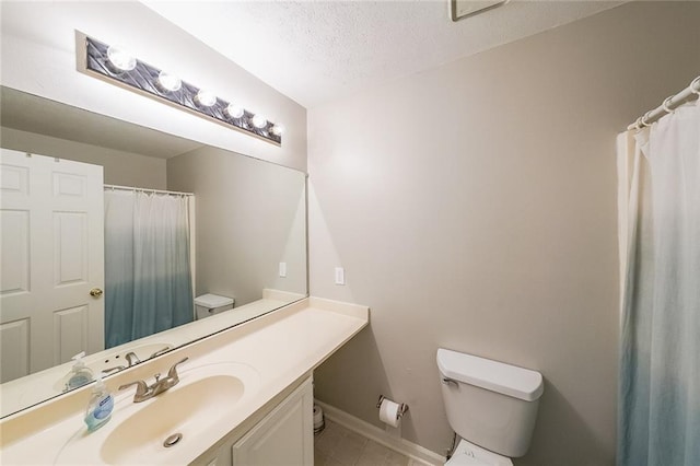 bathroom with vanity, baseboards, tile patterned flooring, a textured ceiling, and toilet