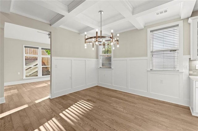 unfurnished dining area with beamed ceiling, a decorative wall, and coffered ceiling