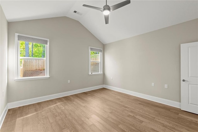 empty room with light wood finished floors, a ceiling fan, visible vents, and lofted ceiling