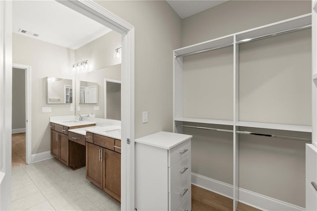bathroom with baseboards, visible vents, and vanity