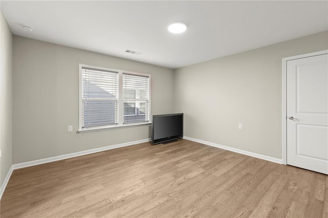 unfurnished room with light wood-style flooring, visible vents, and baseboards