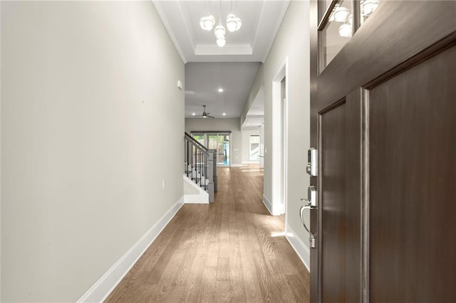hallway featuring stairway, crown molding, wood finished floors, baseboards, and recessed lighting
