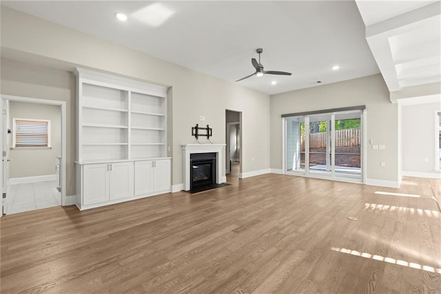 unfurnished living room with recessed lighting, a fireplace with flush hearth, light wood-type flooring, baseboards, and ceiling fan