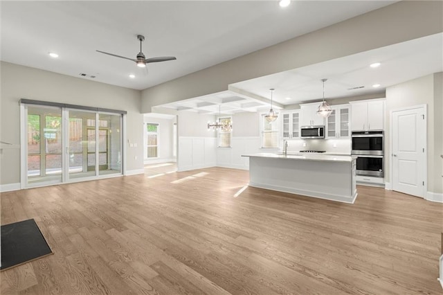unfurnished living room featuring a sink, light wood-style floors, ceiling fan, visible vents, and recessed lighting
