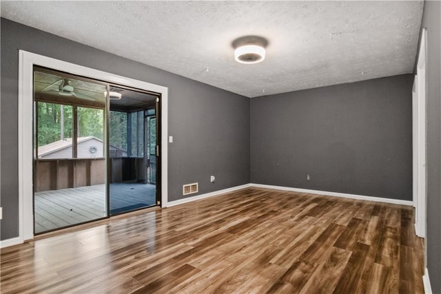 6945 Butner Rd, Atlanta, GA 30349 - unfurnished bedroom featuring visible vents, wood finished floors, baseboards, access to outside, and a textured ceiling