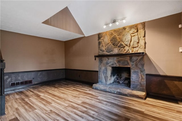 6945 Butner Rd, Atlanta, GA 30349 - unfurnished living room featuring a fireplace, a wainscoted wall, wood finished floors, lofted ceiling, and visible vents