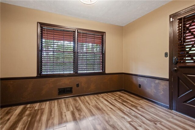 6945 Butner Rd, Atlanta, GA 30349 - spare room featuring a textured ceiling, visible vents, a wealth of natural light, and wood finished floors