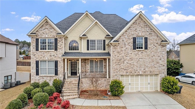 view of front of property with brick siding, a porch, a shingled roof, a garage, and driveway