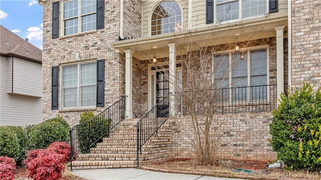 property entrance with brick siding and a porch