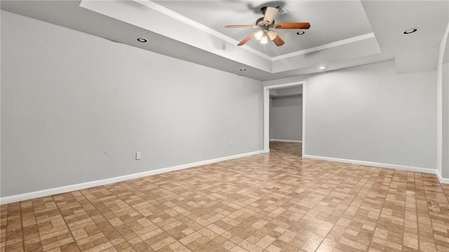 spare room with recessed lighting, a ceiling fan, baseboards, ornamental molding, and a tray ceiling