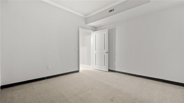 carpeted empty room with visible vents, baseboards, and crown molding