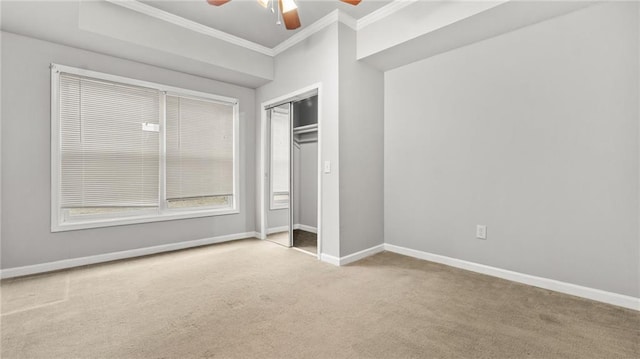 unfurnished bedroom featuring carpet, a closet, ornamental molding, ceiling fan, and baseboards