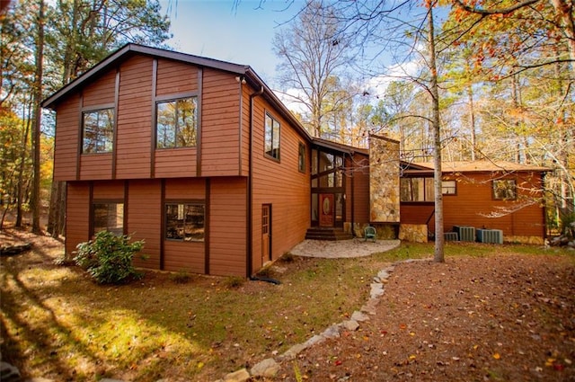 view of home's exterior featuring central AC unit and a lawn