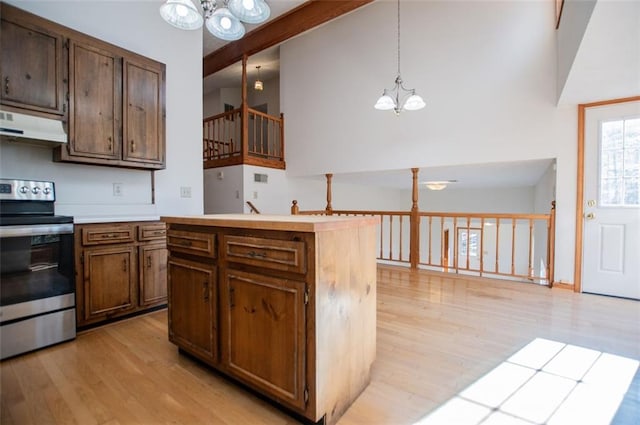 kitchen featuring decorative light fixtures, stainless steel stove, a notable chandelier, and light hardwood / wood-style floors