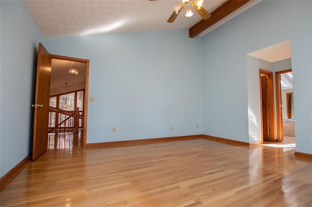 empty room featuring lofted ceiling with beams, light hardwood / wood-style floors, and ceiling fan with notable chandelier