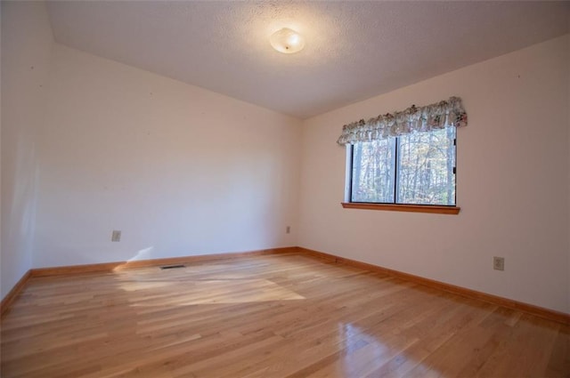 unfurnished room featuring hardwood / wood-style floors and a textured ceiling