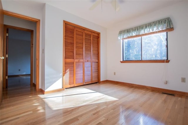 unfurnished bedroom with ceiling fan, a closet, and light hardwood / wood-style floors