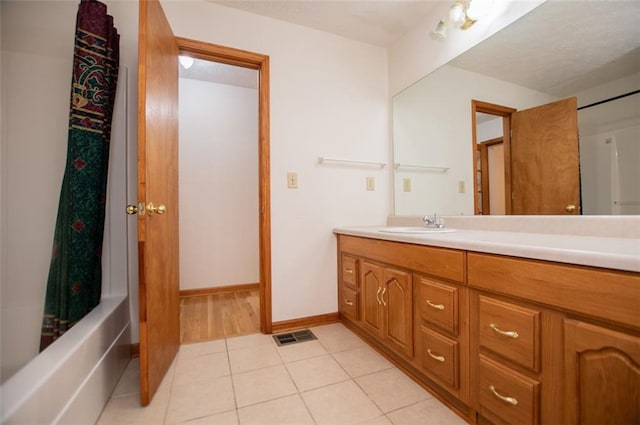 bathroom featuring tile patterned flooring, vanity, and shower / bath combo