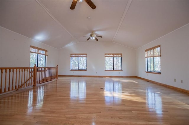 unfurnished room with lofted ceiling, a healthy amount of sunlight, and light hardwood / wood-style floors