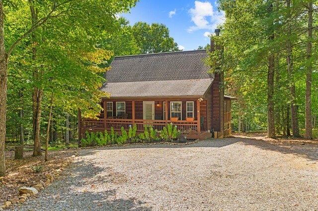 log home featuring covered porch