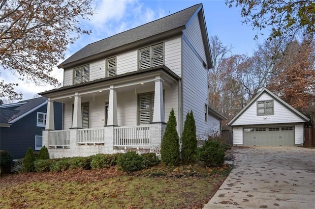 view of front of home featuring a porch, a garage, and an outbuilding