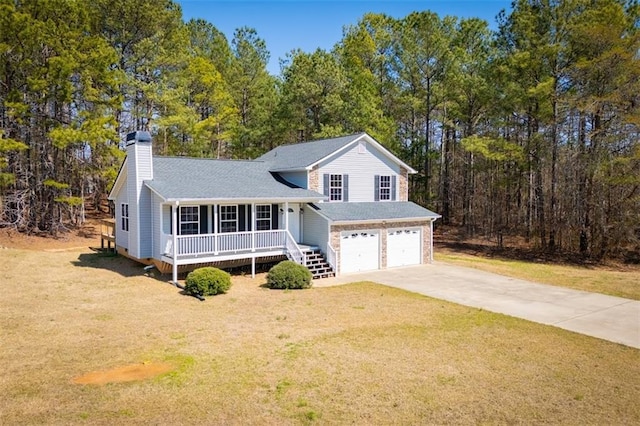 tri-level home featuring covered porch, concrete driveway, a front yard, a shingled roof, and a garage