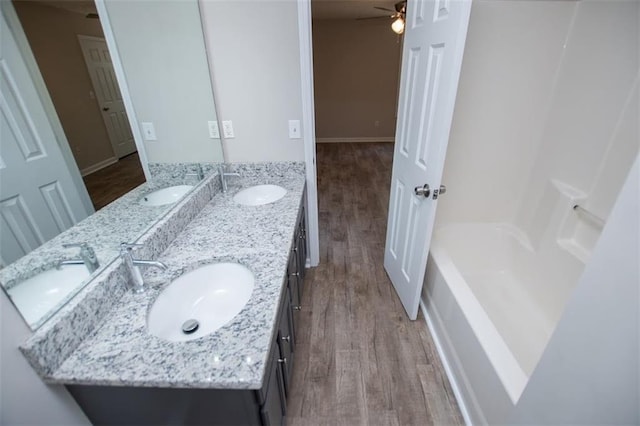 bathroom featuring a sink, wood finished floors, and double vanity