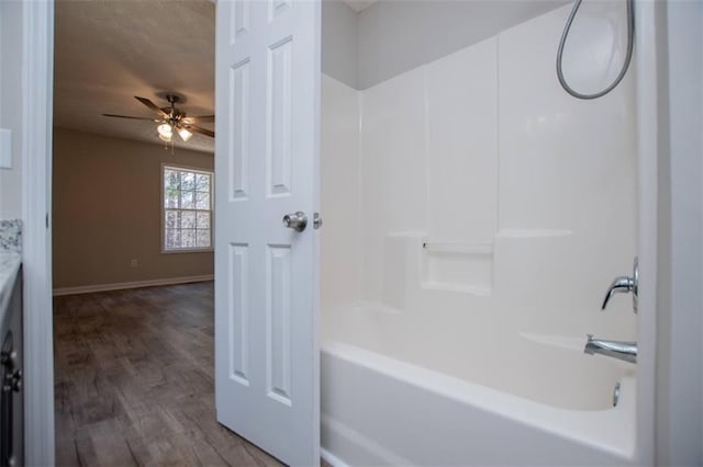 full bathroom with shower / bath combination, wood finished floors, baseboards, and ceiling fan