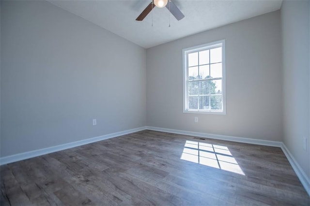 spare room with visible vents, baseboards, wood finished floors, and a ceiling fan