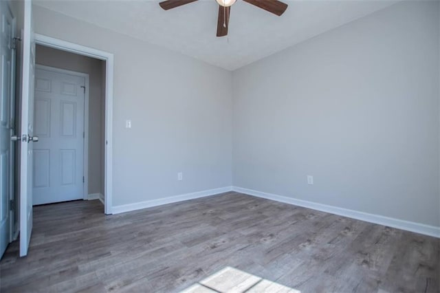 unfurnished room with baseboards, a ceiling fan, and wood finished floors