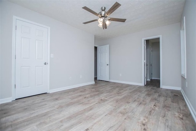 unfurnished bedroom featuring a textured ceiling, a ceiling fan, baseboards, and wood finished floors