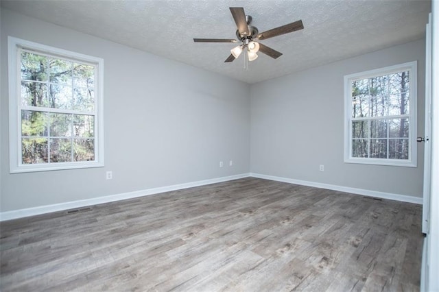 unfurnished room featuring baseboards, a textured ceiling, wood finished floors, and a ceiling fan