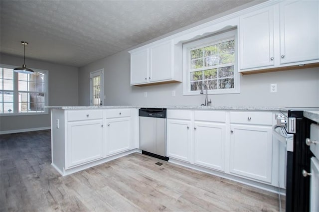 kitchen with light wood finished floors, appliances with stainless steel finishes, a textured ceiling, and a peninsula