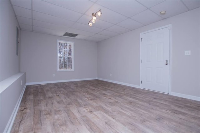 unfurnished room with a drop ceiling, baseboards, and wood finished floors