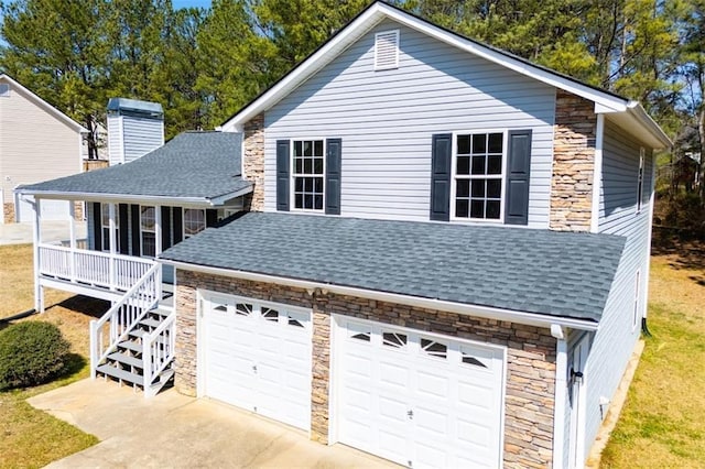 view of front of house with stone siding, an attached garage, and a shingled roof