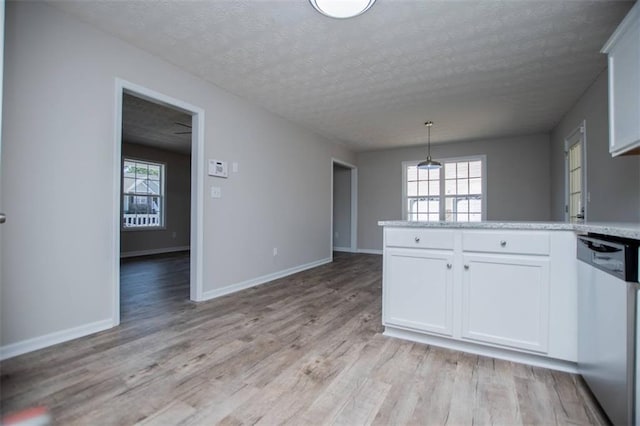 kitchen with stainless steel dishwasher, white cabinetry, light wood finished floors, baseboards, and light countertops