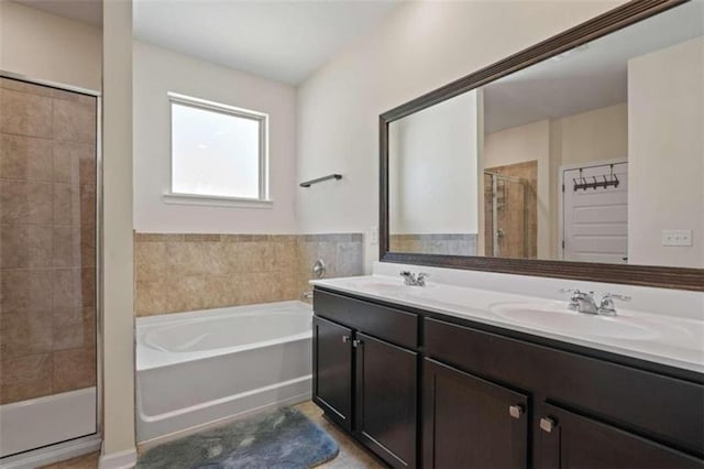 full bath with a garden tub, double vanity, a stall shower, and a sink