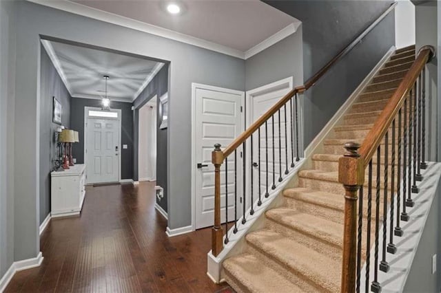 foyer featuring crown molding, dark wood-style flooring, stairs, and baseboards