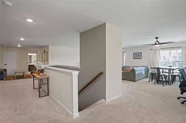 corridor with light carpet, recessed lighting, baseboards, and an upstairs landing