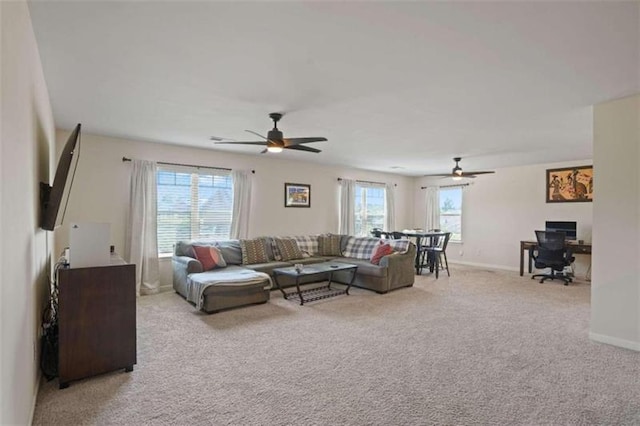 living area featuring light carpet, baseboards, and a ceiling fan