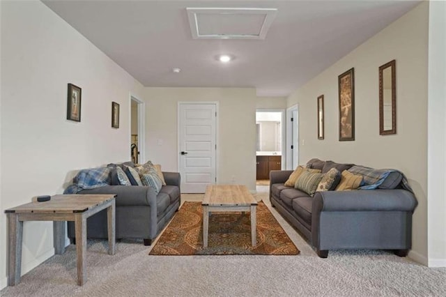 living room with light carpet, attic access, and baseboards