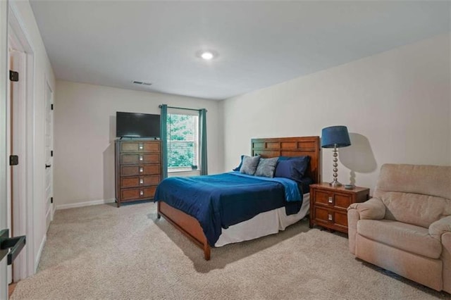 bedroom featuring visible vents, baseboards, and light colored carpet