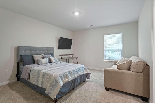 bedroom with baseboards and light colored carpet