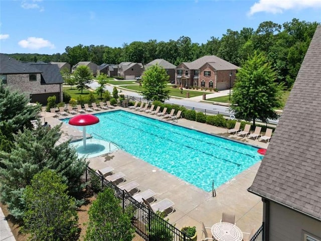 community pool featuring a residential view, fence, and a patio