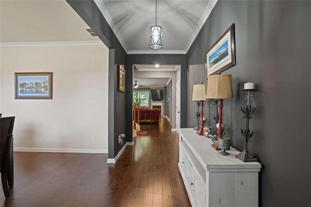 hall featuring dark wood-style floors, baseboards, and crown molding