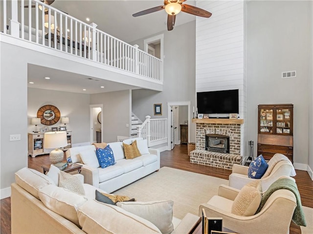 living room featuring stairway, wood finished floors, baseboards, and ceiling fan