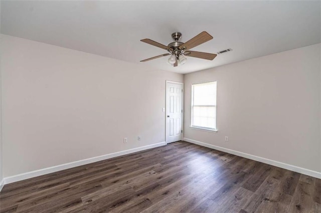 spare room with dark hardwood / wood-style flooring and ceiling fan